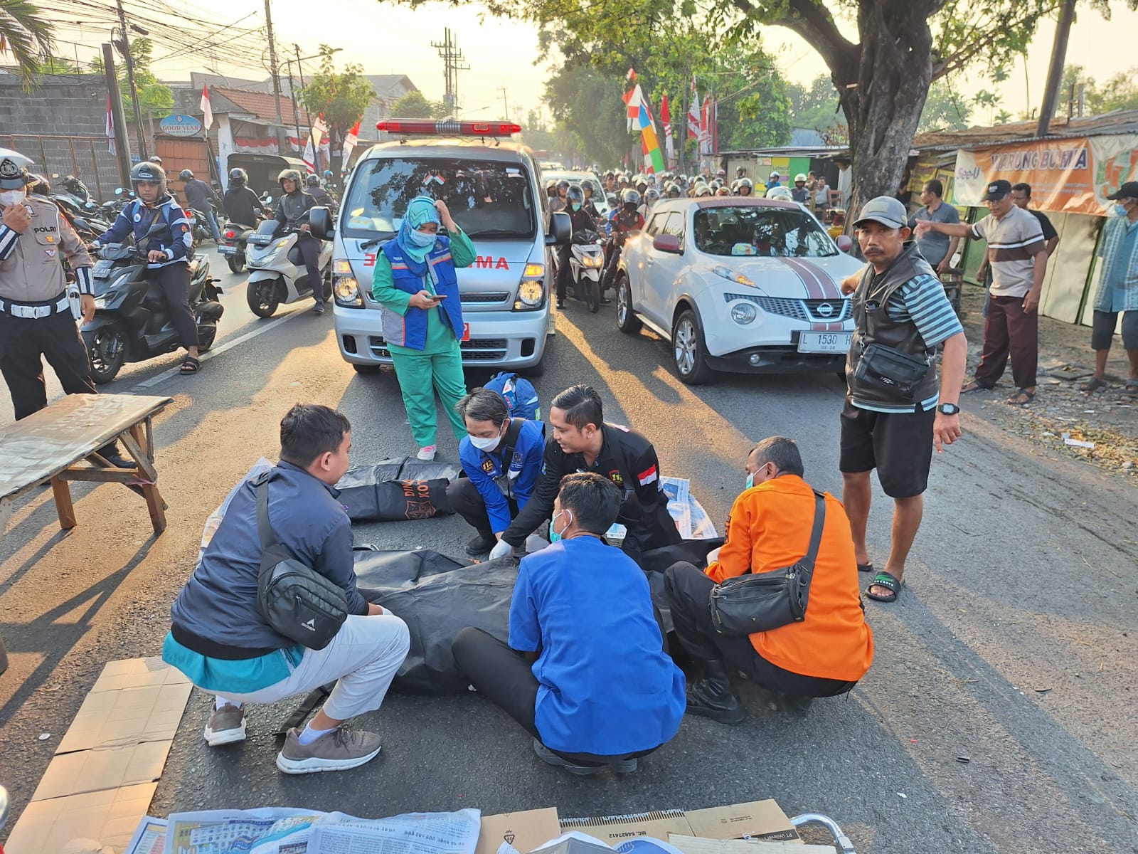 EVAKUASI : Petugas mengevakuasi jenazah korban pelajar yang terlintas truk di Jalan Mastrip, Karangpilang, Surabaya.(IST/RADAR SURABAYA)
