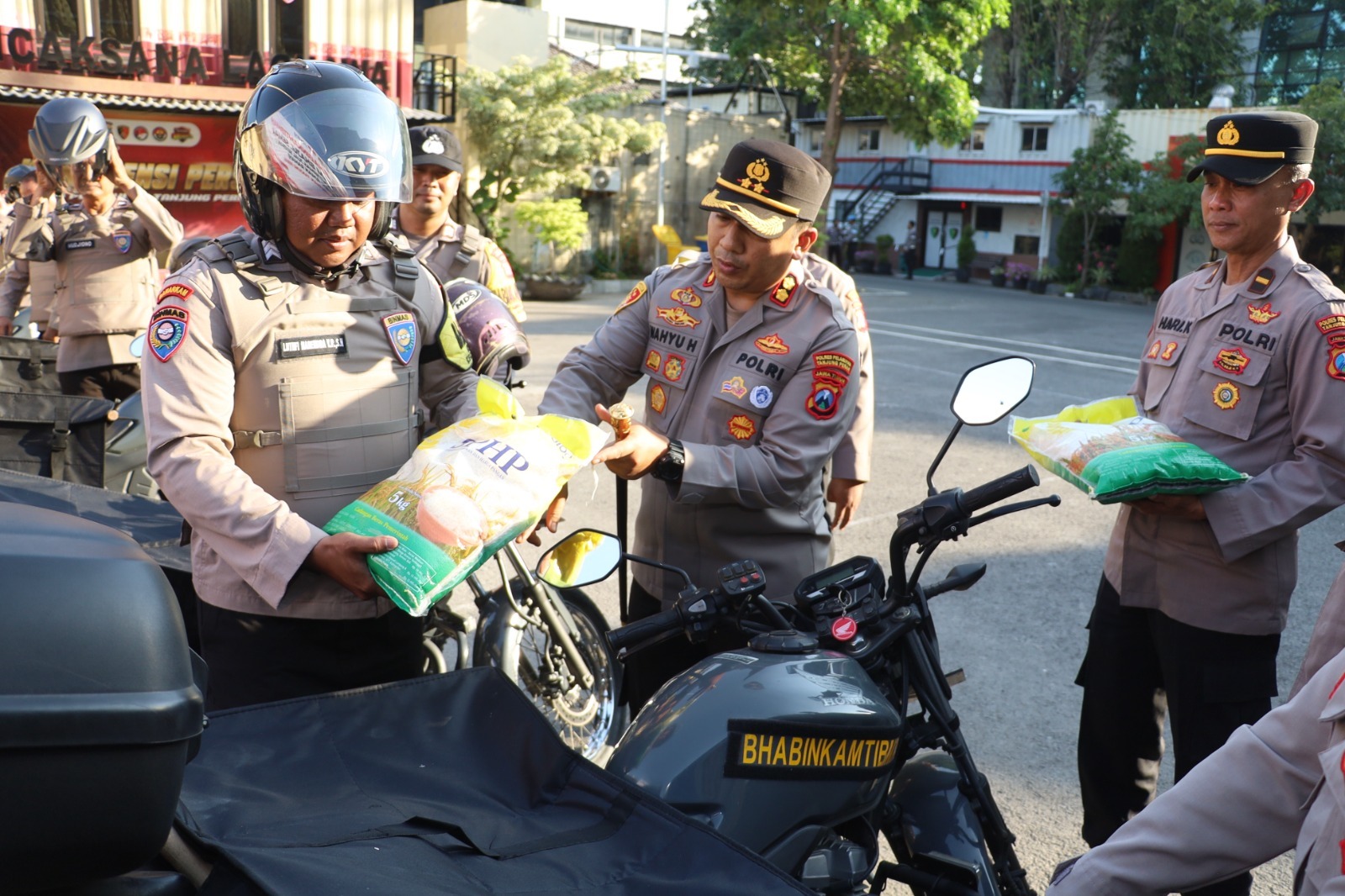 JEMPUT BOLA : Kapolres Pelabuhan Tanjung Perak AKBP Wahyu Hidayat menyerahkan beras murah untuk didistribusikan ke masyarakat Surabaya melalui Bhajul Semar.(IST/RADAR SURABAYA)