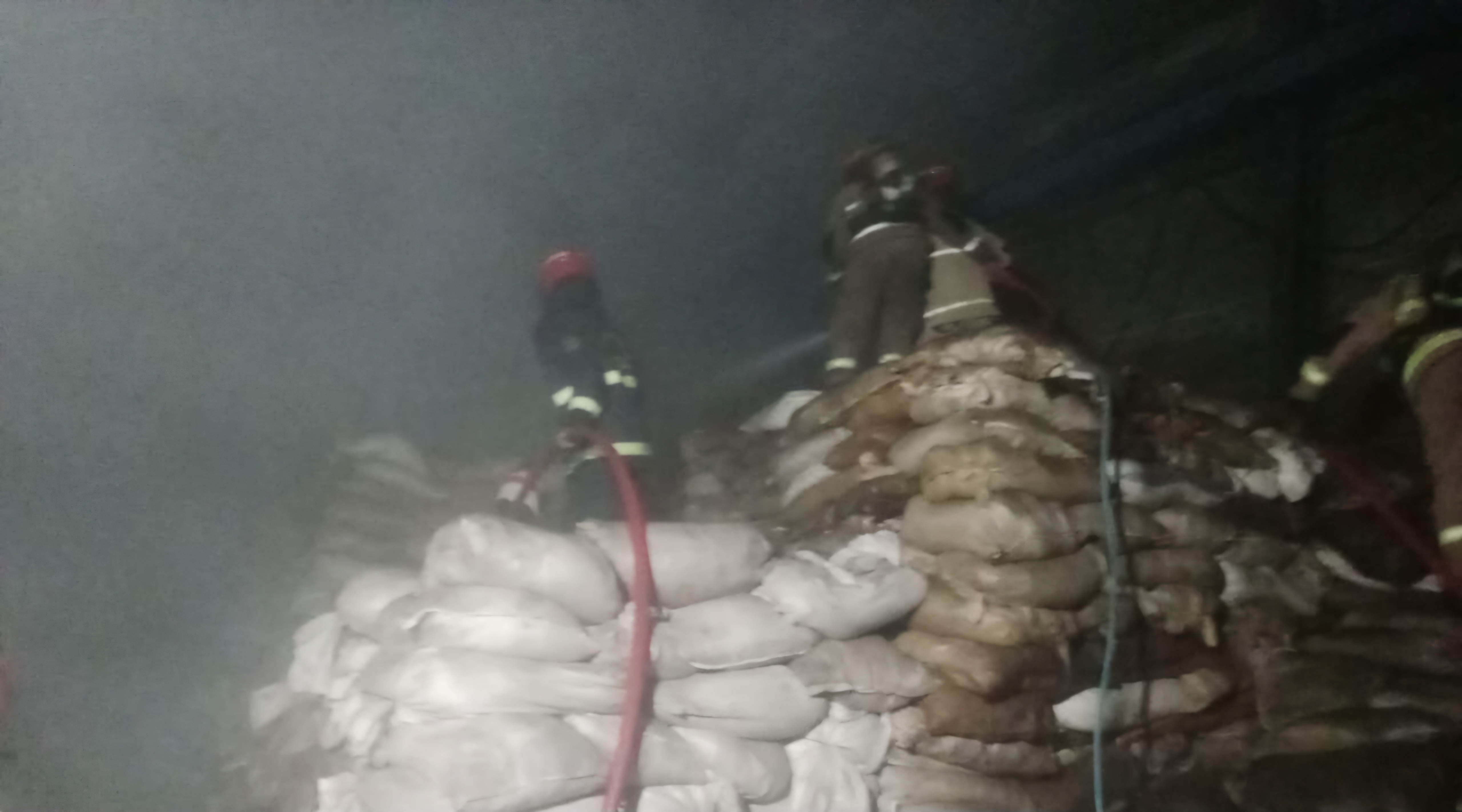 SIGAP : Petugas DPKP Surabaya melakukan pemadaman tumpukan karung berisi kemiri yang terbakar di gudang Jalan Demak, Surabaya, Kamis (14/8). (IST/RADAR SURABAYA)
