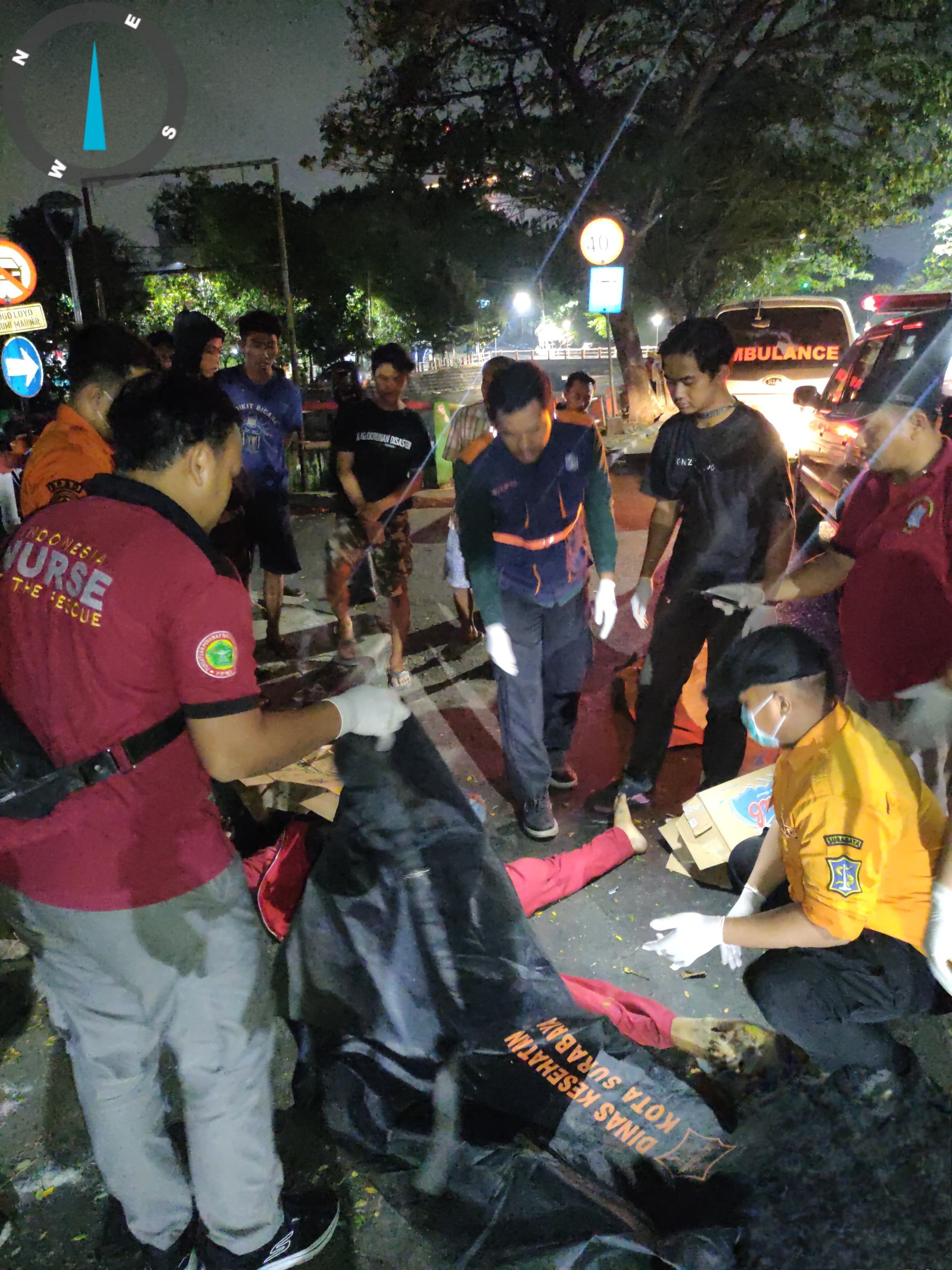 EVAKUASI: Petugas mengevakuasi jenazah korban pengendara motor di Jalan Gunungsari, Surabaya. Korban diduga menabrak pembatas hingga meninggal dunia. (IST/RADAR SURABAYA)