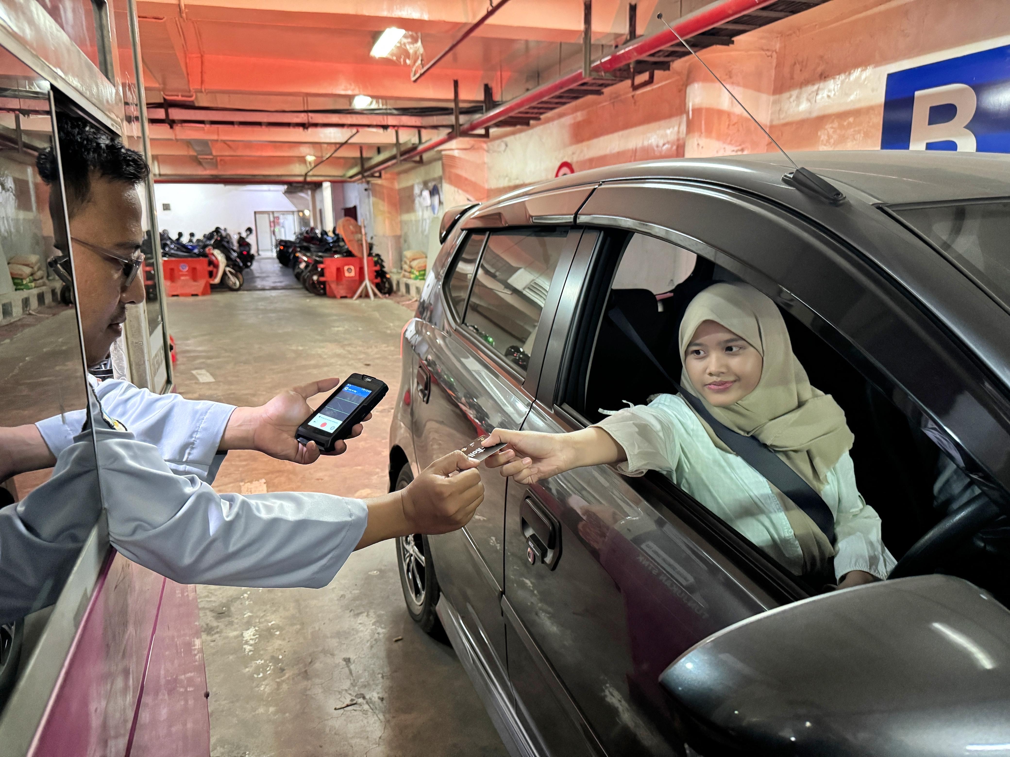 Pengendara membayar karcis dengan uang digital QRIS di Surabaya. (IST)
