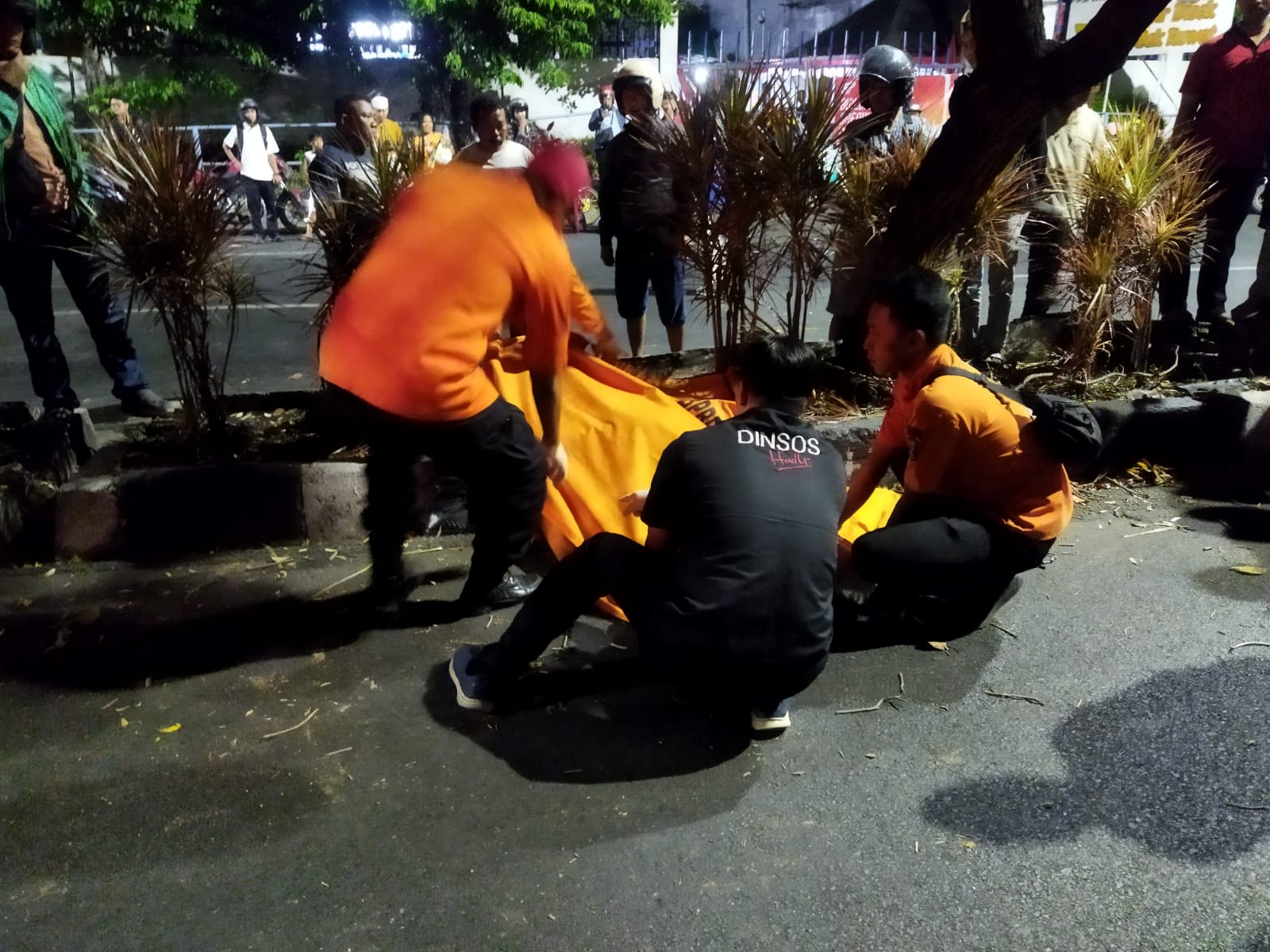 NAHAS : Petugas gabungan mengevakuasi jasad korban. Diduga korban menabrak pembatas dan pohon di Jalan Panjang Jiwo, Surabaya, Kamis malam (14/8). (IST/RADAR SURABAYA)