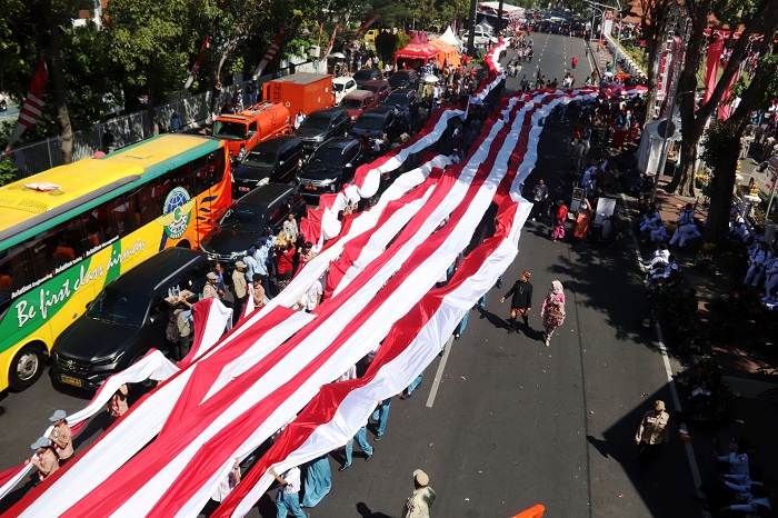 REKOR: Sebanyak 10.868 pelajar Jatim membentangkan bendera merah putih sepanjang 15.273 meter dalam upaya pemecahan rekor Muri di peringatan HUT ke-80 Kemerdekaan, di Gedung Negara Grahadi, Surabaya