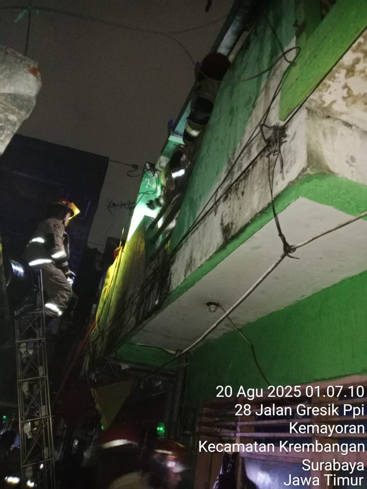 PEMADAMAN: Petugas DPKP Surabaya memadamkan api di lantai II rumah Jalan Gresik PPI Pasar, Surabaya, yang terbakar. (IST/RADAR SURABAYA)