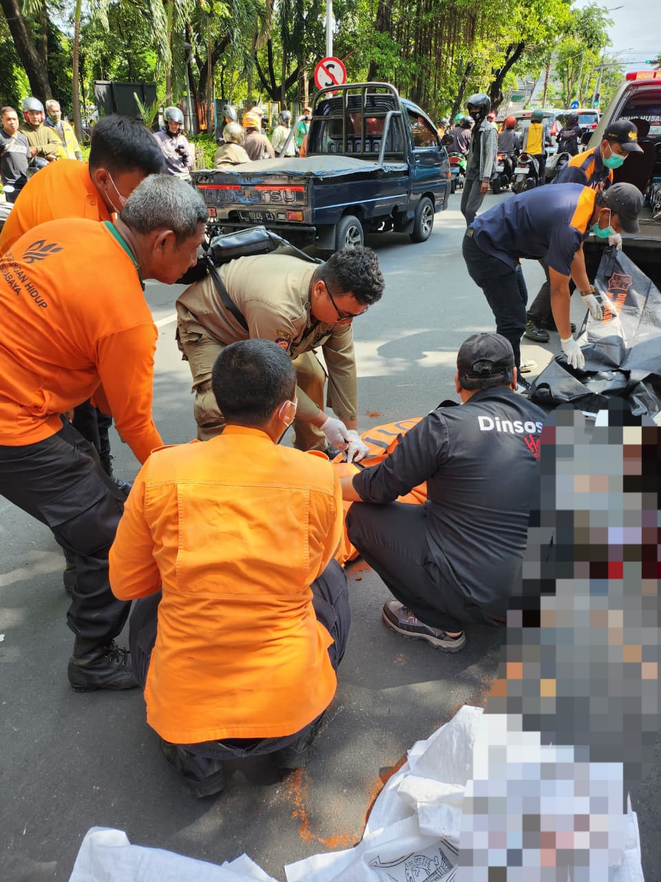 EVAKUASI: Petugas saat mengevakuasi jenazah pengendara motor yang terlibat kecelakaan di Jalan Manyar, Surabaya. (IST/RADAR SURABAYA)
