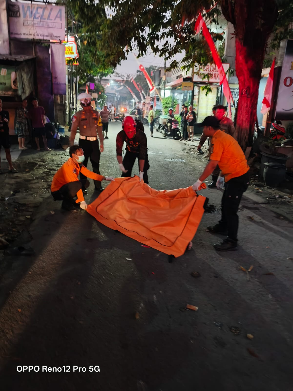 NAHAS : Petugas mengevakuasi jasad korban pengendara motor di Jalan Kebonsari Tengah, Surabaya, Kamis (21/8). (IST/RADAR SURABAYA)