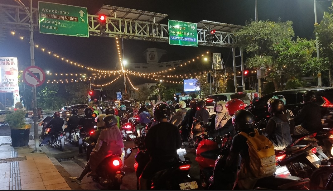 Pengendara motor tanpa lampu belakang melintas di malam hari. Kondisi ini berisiko tinggi sebabkan kecelakaan lalu lintas.