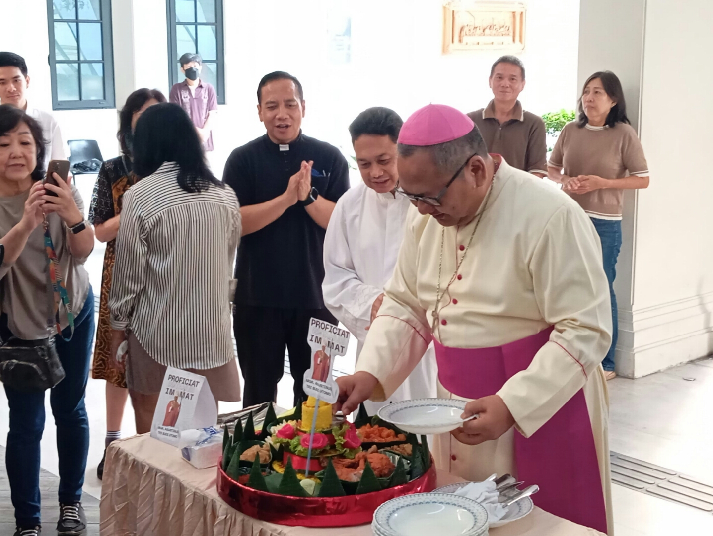 Uskup Surabaya Agustinus Tri Budi Utomo memotong tumpeng saat syukuran 29 tahun imamatnya. (IST)