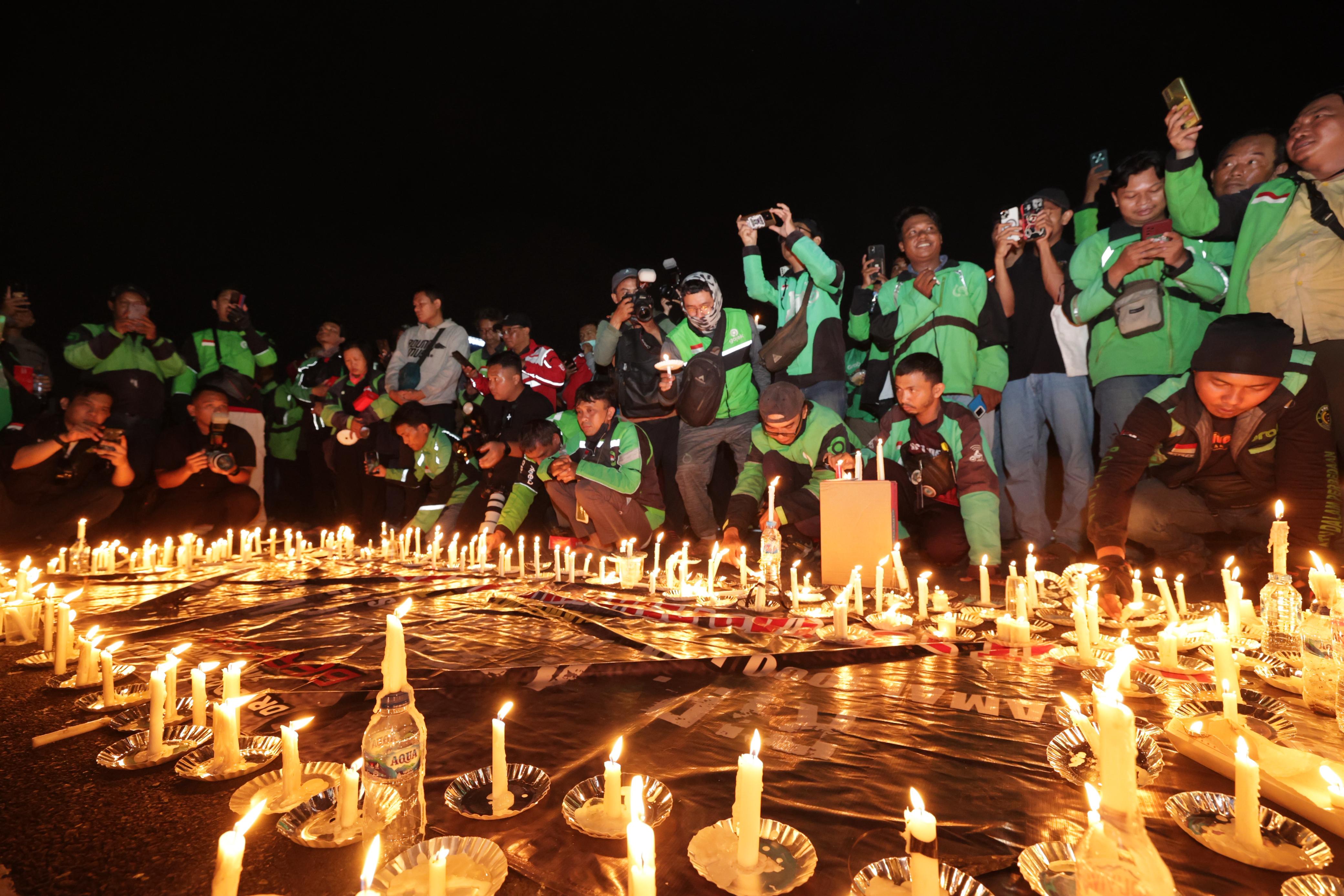 BELA SUNGKAWA: Ratusan driver ojol aksi damai 1000 lilin di Mapolda Jatim. (IST/RADAR SURABAYA)