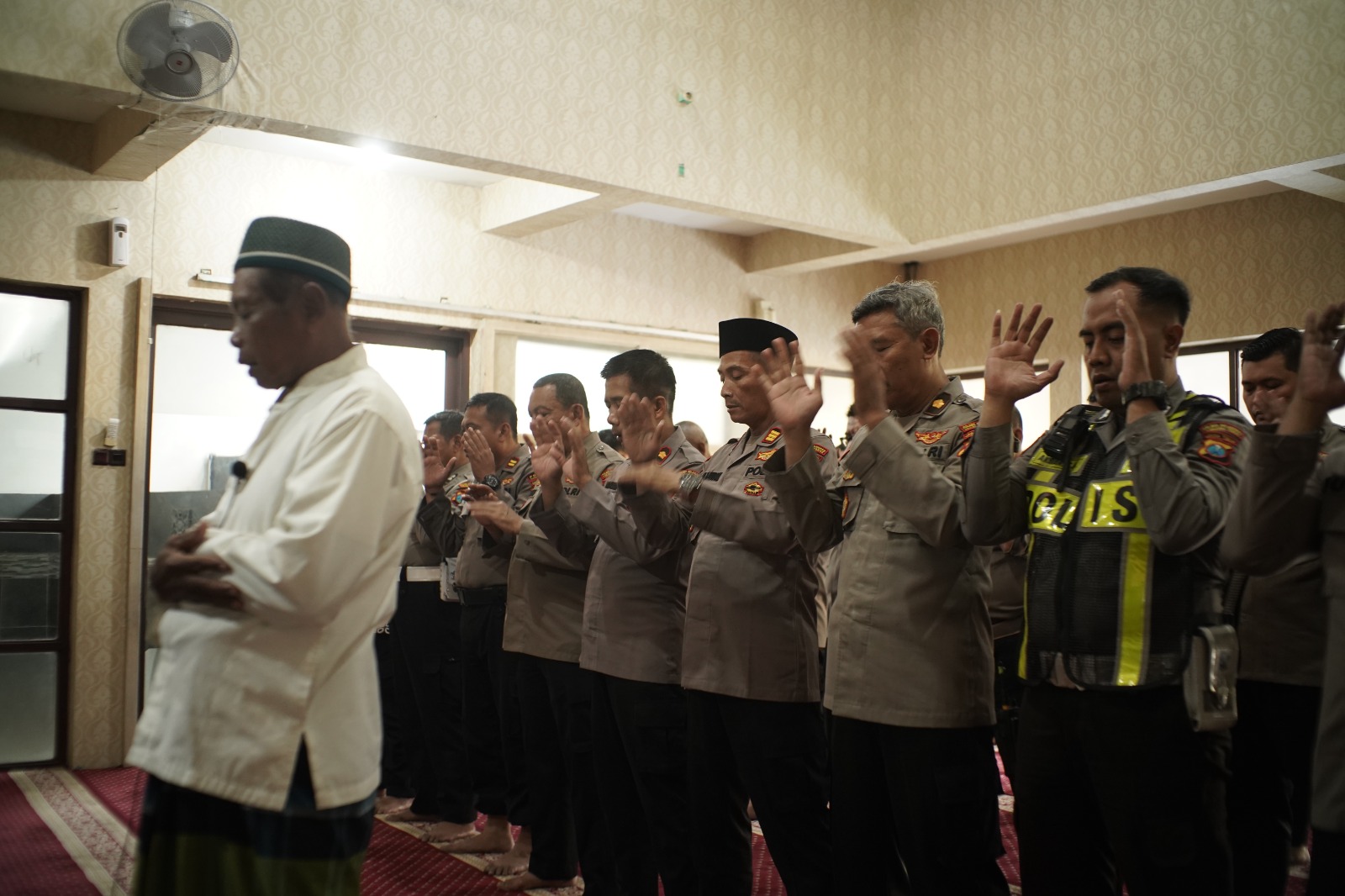 KHUSYUK: Polres Pelabuhan Tanjung Perak melaksanakan salat gaib untuk pengendara ojol yang meninggal dunia di Jakarta. (IST/RADAR SURABAYA)