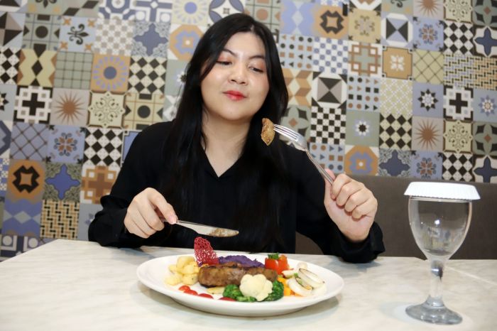 KREASI STEAK: Avinanda, menikmati sajian menu unik, yakni tenderloin steak yang dikombinasikan dengan ubi ungu, di Grand Darmo Suite Hotel Surabaya, Senin (1/9).