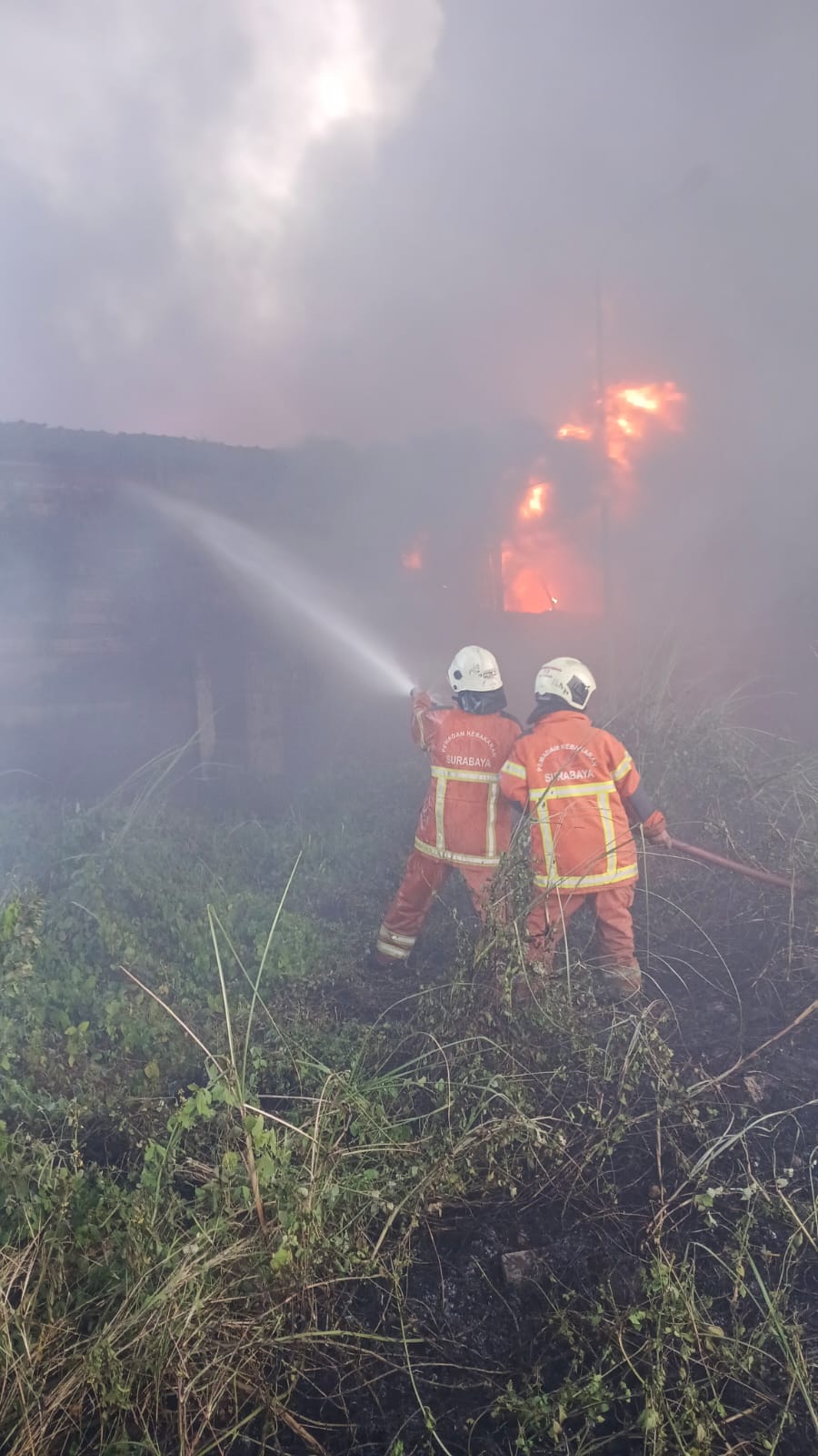MEMBARA : Petugas DPKP Surabaya berjibaku memamdamkan api yang membakar gudang rongsokan plastik di Jalan Margomulyo Tandes Surabaya, Rabu (3/9). (IST/RADAR SURABAYA)