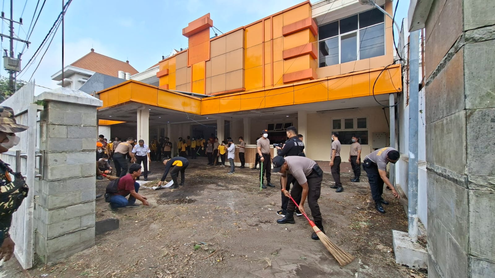 BERSIH-BERSIH: Anghota Polsek Tegalsari mulai membersihkan kantor Bawaslu di Jalan Tanggulangin, Surabaya, untuk ditempati sementara.(MAHRUS/RADAR SURABAYA)
