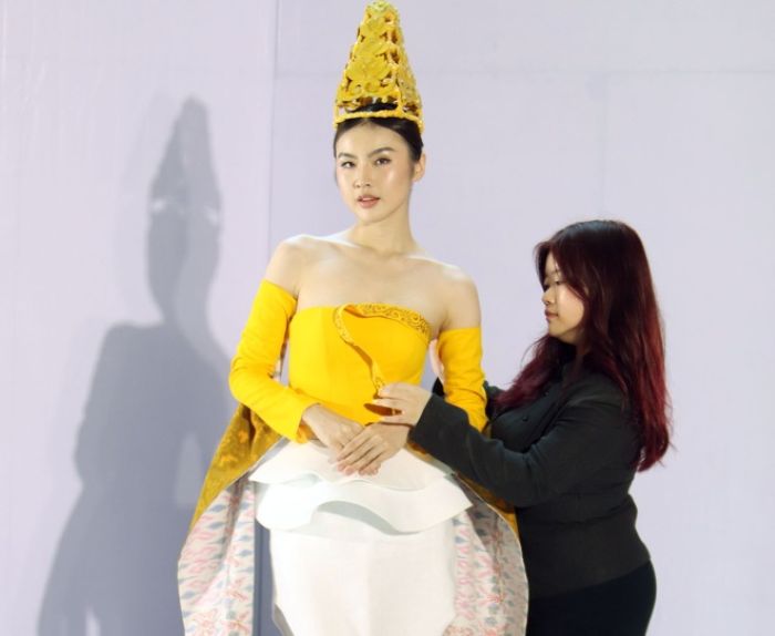 BUSANA BUDAYA: Valen Handoko (kanan), mahasiswa Textile and Fashion Design (DFT) Petra Christian University (PCU) Surabaya merapikan busana karyanya, sebelum ditampilkan dalam peragaan busana.