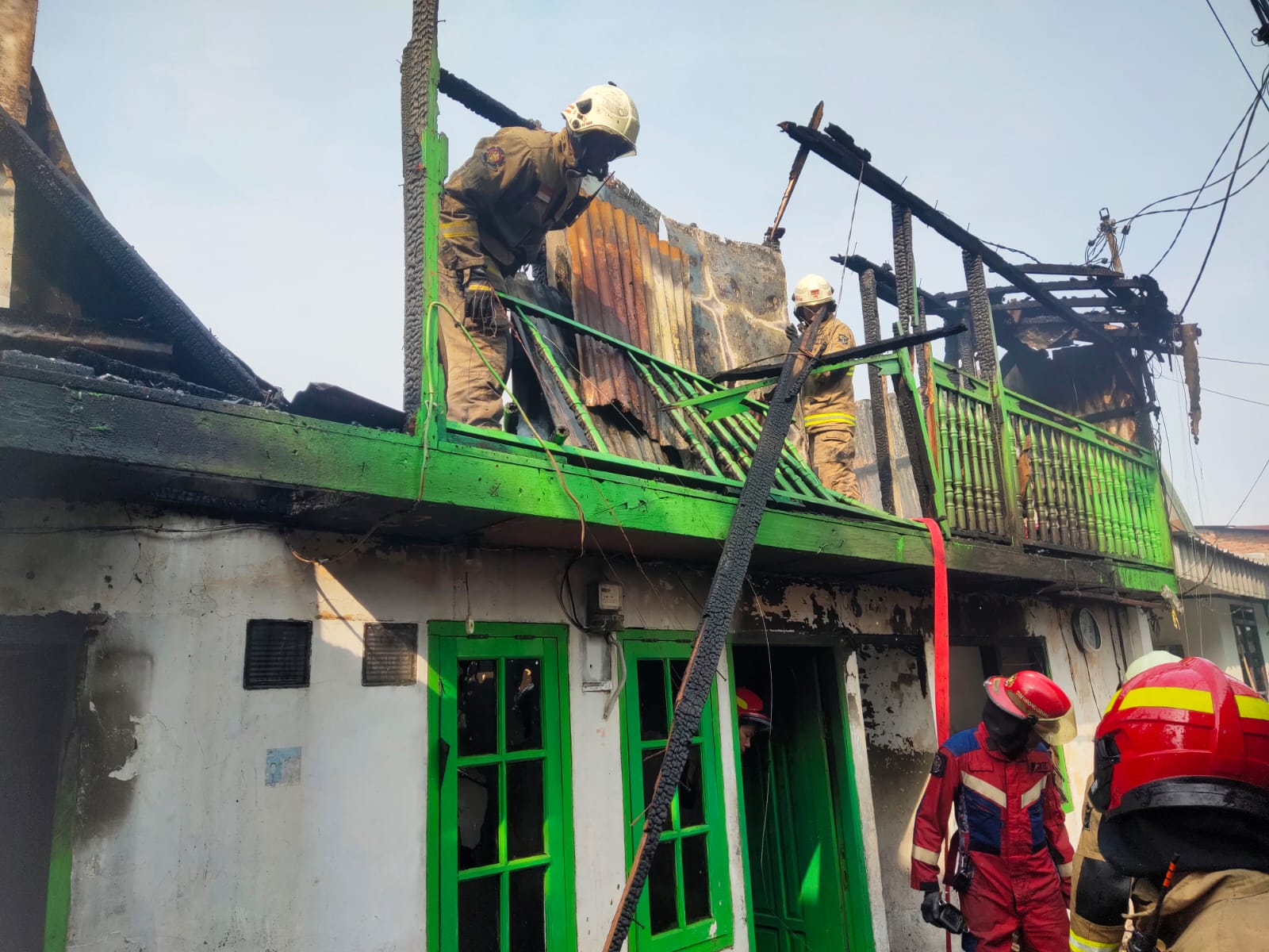 PEMBASAHAN: Petugas DPKP Surabaya saat melakukan pembasahan kebakaran rumah di Jalan Dupak Timur, Surabaya. Satu orang meninggal dunia dalam kejadian tersebut.(IST/RADAR SURABAYA)