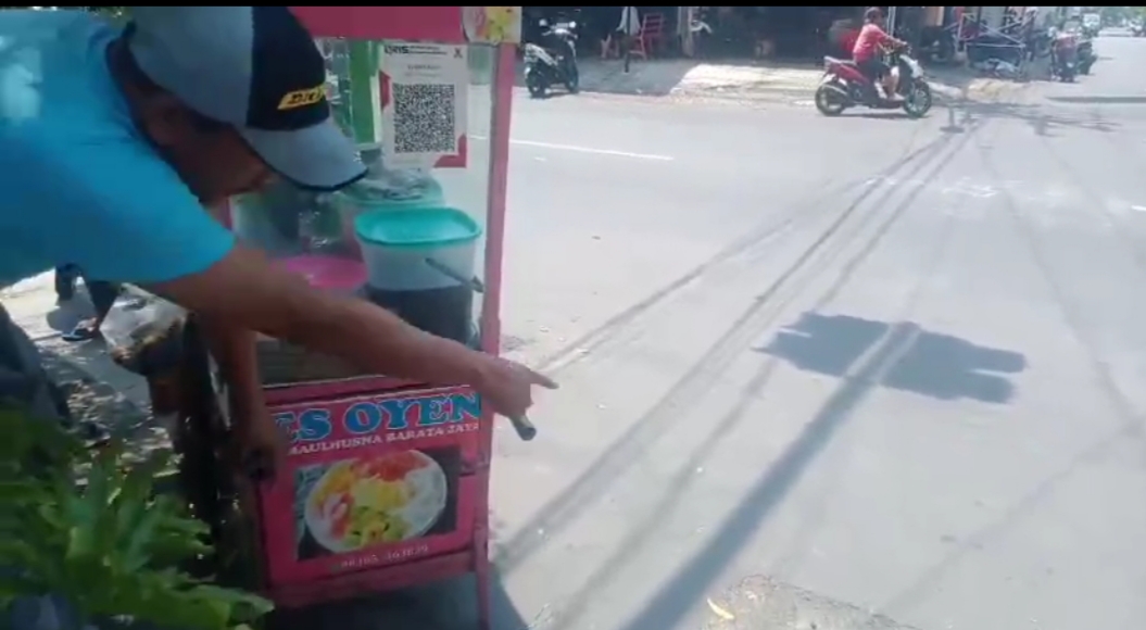 LOKASI : Salah satu saksi aksi jambret menunjukkan lokasi korban dijambret di depan gapura Jalan Barata Jaya III, Surabaya. (IST/RADAR SURABAYA)