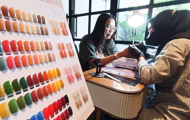 TREN NAIL ART: Mery Suhartatik, nail artist asal Surabaya, melakukan perawatan kuku salah satu pelanggannya, Minggu (7/9).