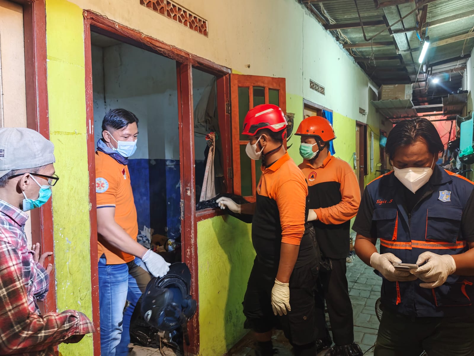 EVAKUASI: Petugas BPBD Surabaya saat mengevakuasi korban dari kamar kos Jalan Platuk Donomulyo, Surabaya. (IST/RADAR SURABAYA)
