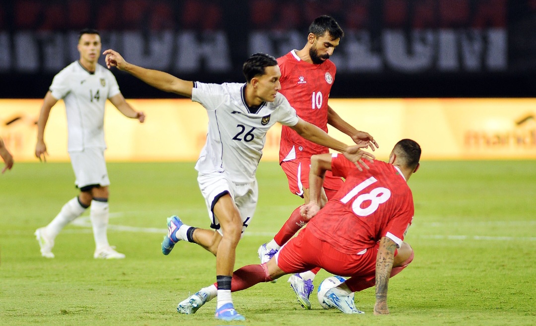 Striker timnas Indonesia Miliano Jonathans coba melewati pemain belakang Lebanon.