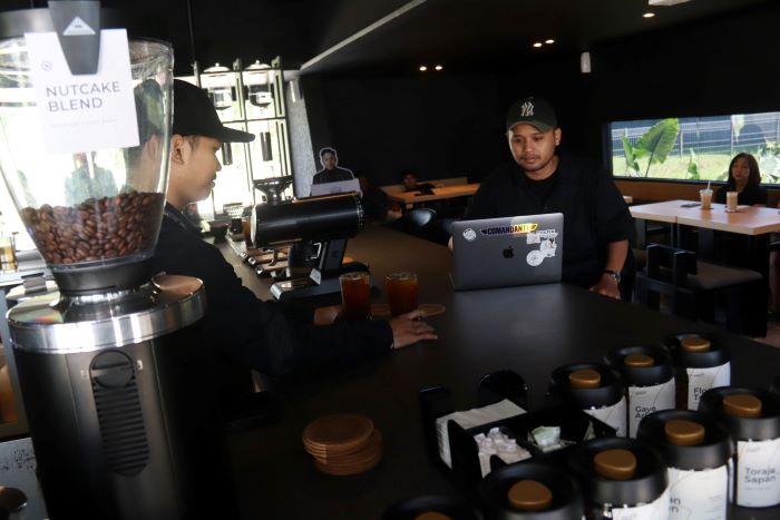 WORK FROM CAFE: Pengunjung menyelesaikan pekerjaan mereka di Kafe Cold and Brew, dengan menikmati sajian kopi yang dihidangkan, Rabu (10/9).