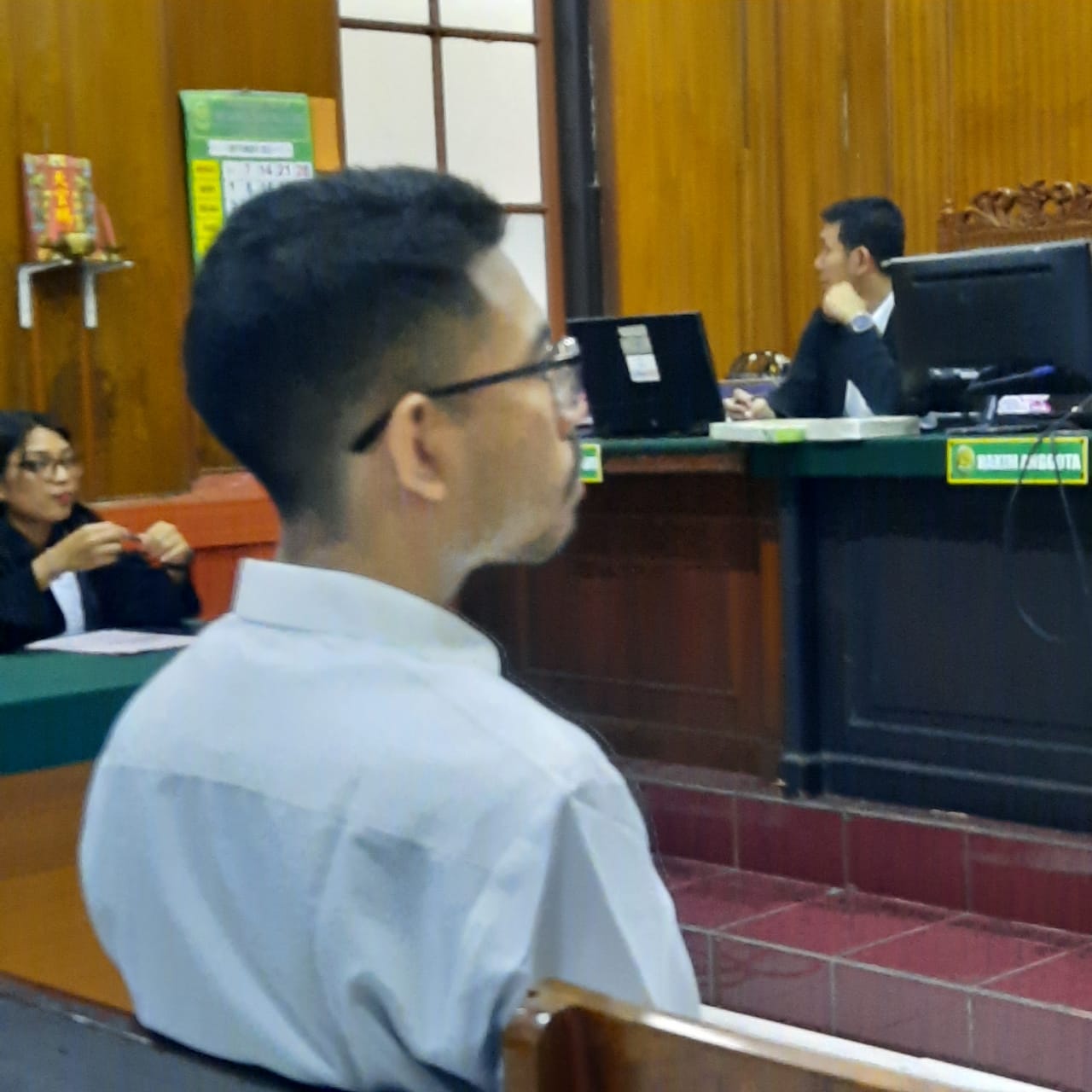 TERTEGUN: Terdakwa saat disidang di PN Surabaya. Ia menipu korbannya bermodus investasi tas impor. (IST/RADAR SURABAYA)