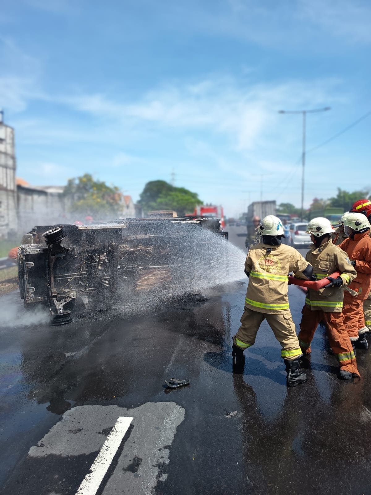 PEMBASAHAN: Petugas DPKP Surabaya saat memadamkan api yang membakar mobil boks di Tol Dupak Surabaya. (IST/RADAR SURABAYA)