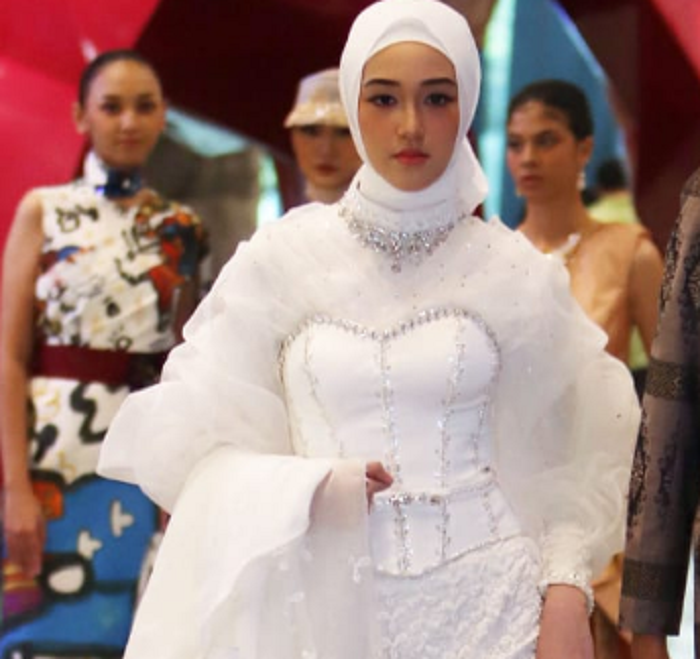 SIMPEL TAPI ELEGAN: Model berpose dengan mengenakan busana pengantin karya desainer asal Surabaya, Whulyan yang mengusung gaya simpel dan elegan, dalam peragaan busana di Surabaya beberapa waktu lalu.