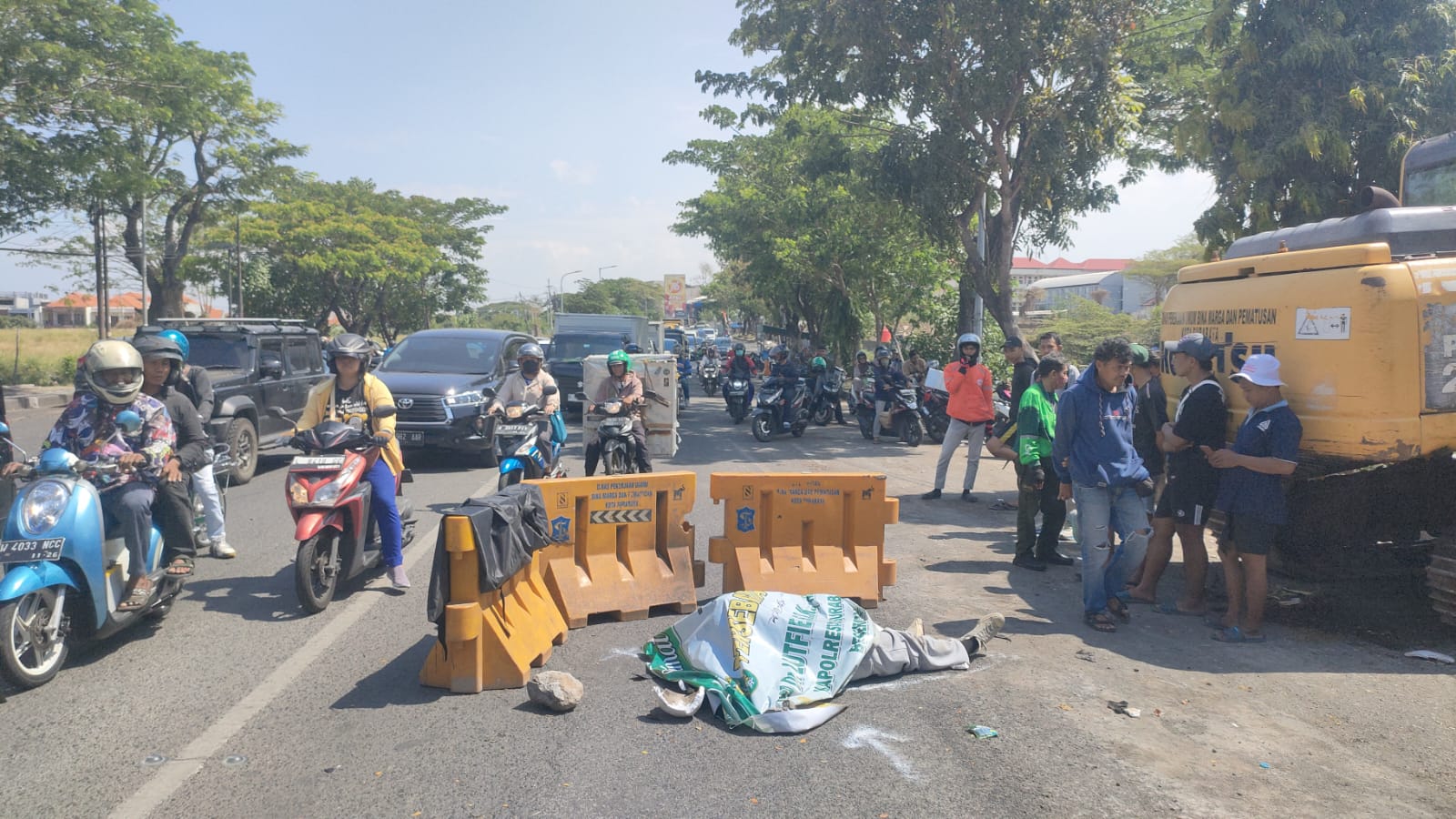 SEBELUM DIEVAKUASI: Jasad korban kecelakaan diduga menabrak barier di Jalan Raya Babatan, Wiyung, Surabaya.(IST/RADAR SURABAYA)