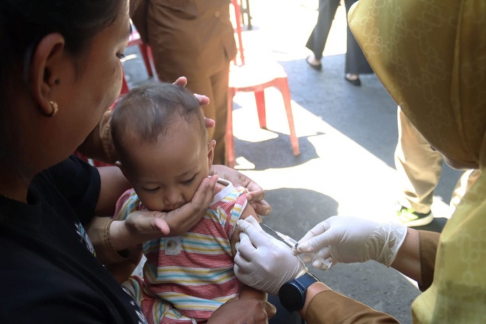 VAKSIN CAMPAK: Petugas kesehatan melakukanj penyuntikan vaksin campak kepada seorang balita, di Posyandu Keluarga (Posga) Kelurahan Tegalsari, Surabaya, Senin (15/9).