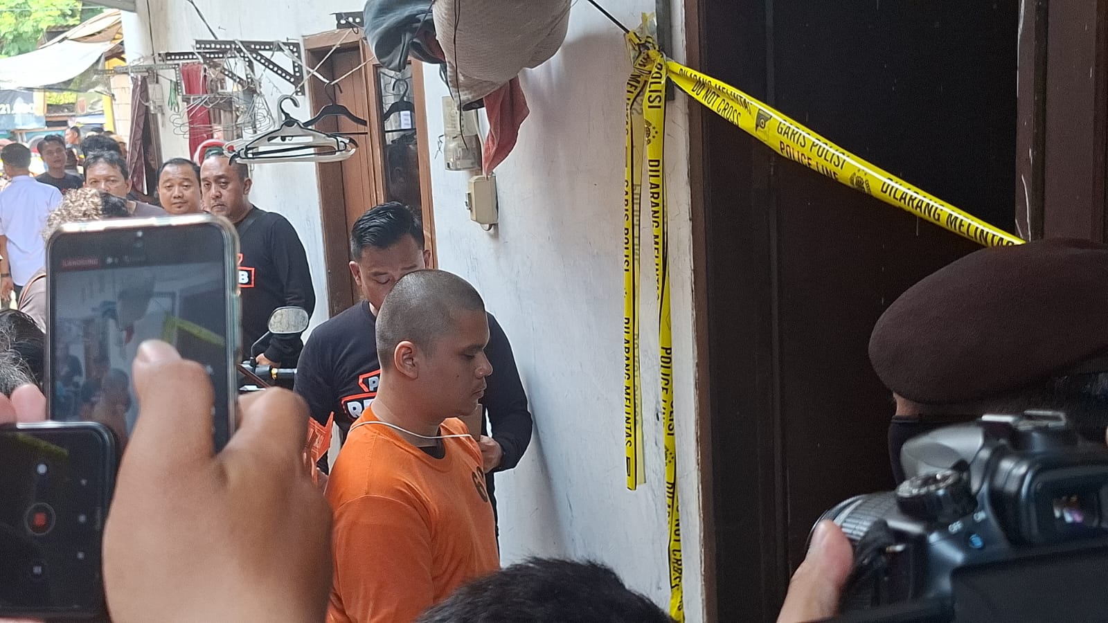 PERAGAKAN: Tersangka Alvi saat memperagakan kejadian ia dikunci di luar kos selama satu jam oleh korban.(M MAHRUS/RADAR SURABAYA)