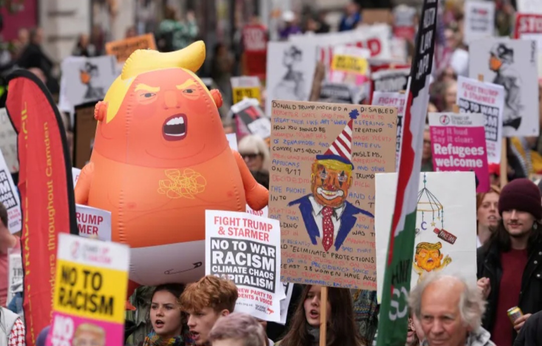 Orang-orang memegang boneka tiup bergambar Presiden AS Donald Trump selama protes dan demonstrasi