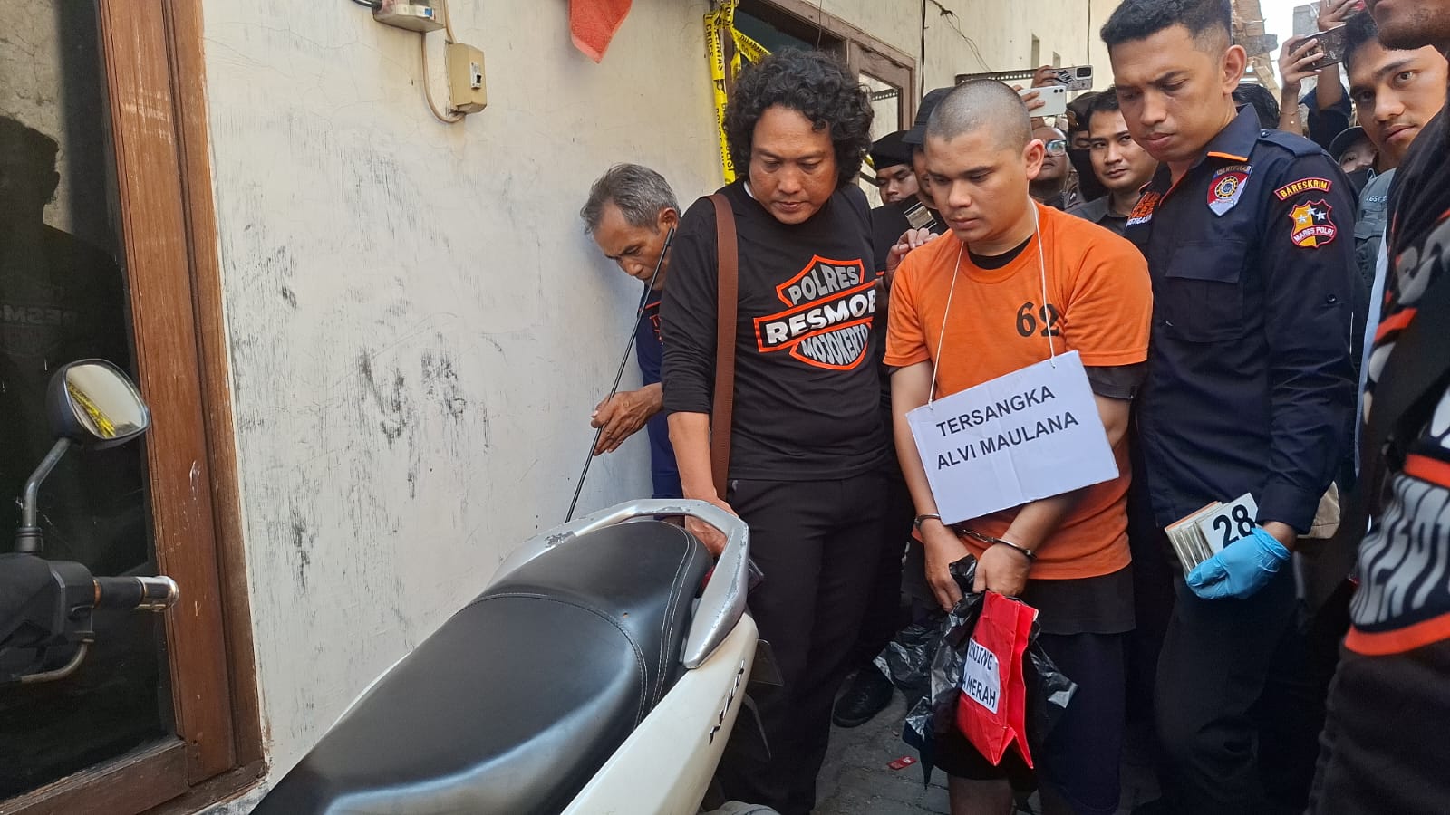MEMPERAGAKAN: Tersangka saat memperagakan adegan kasus mutilasi di tempat kos Lidah Wetan, Surabaya. (MAHRUS/RADAR SURABAYA)