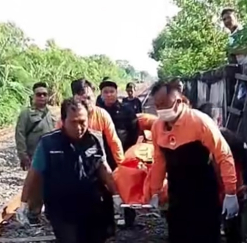 DIGOTONG : Petugas gabungan mengevakuasi jasad KD, 57, yang ditemukan meninggal dunia diduga tertabrak KA di pinggir rel Jalan Kalibokor, Surabaya.(IST/RADAR SURABAYA)