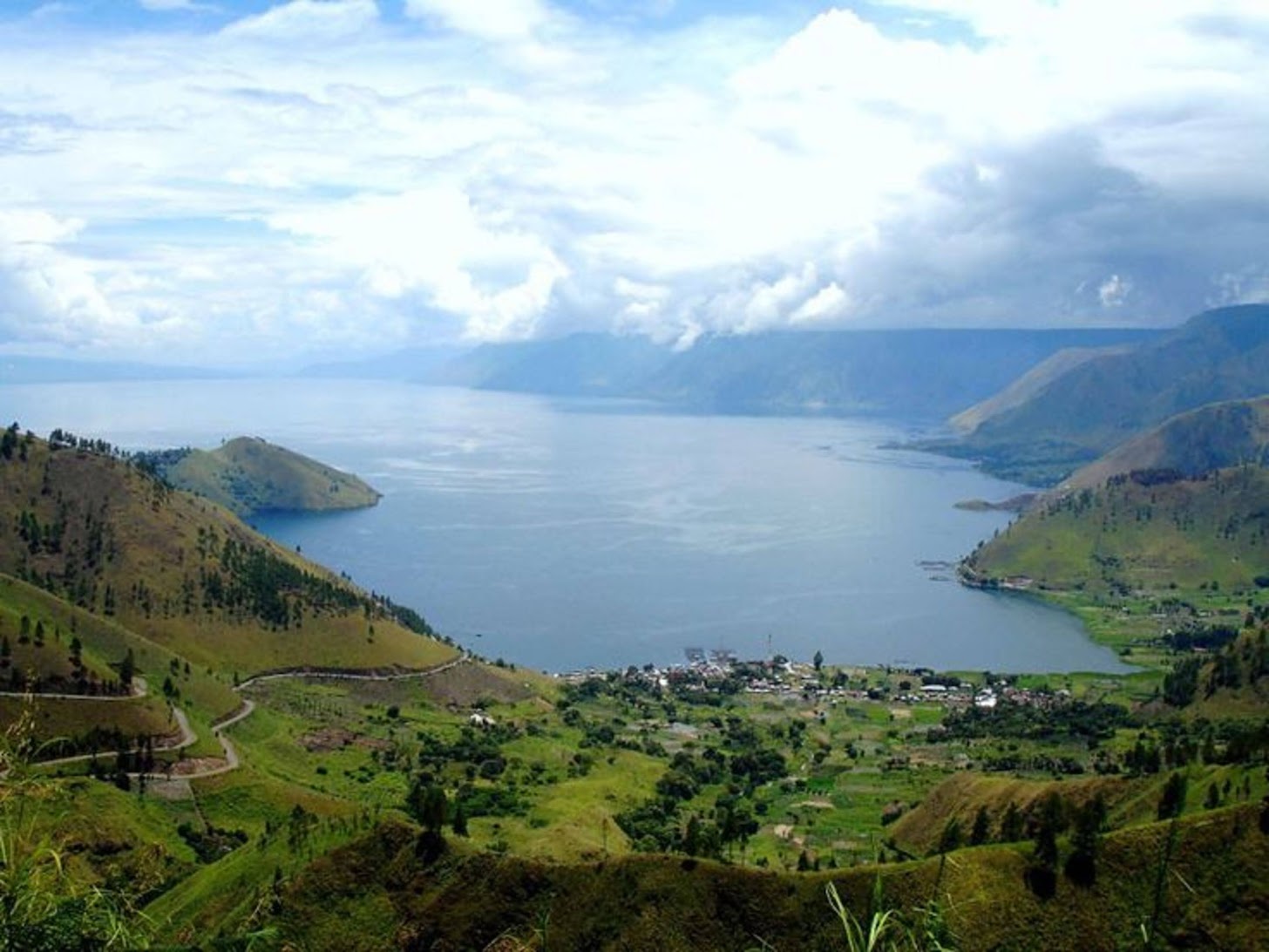 Danau Toba dengan Pulau Samosir di tengahnya, ikon alam Sumatera Utara yang terbentuk dari letusan supervulkanik ribuan tahun silam.