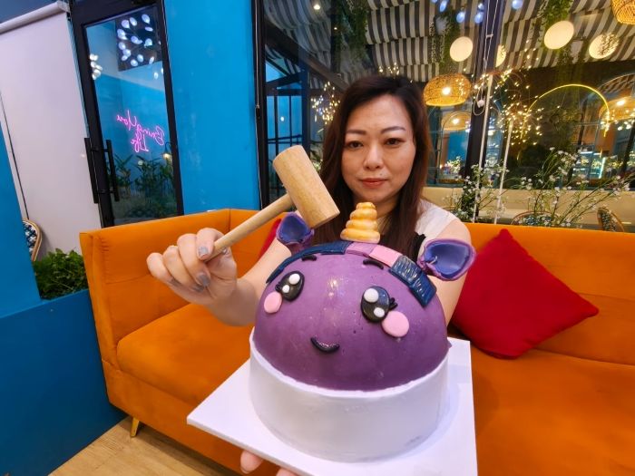 SENSASI NIKMATI GELATO: Irene Amelinda menunjukkan cara menikmati Pinata Gelato dengan cara diketok menggunakan palu kayu, di Rocco Gelato Citraland Surabaya, Senin (22/9).