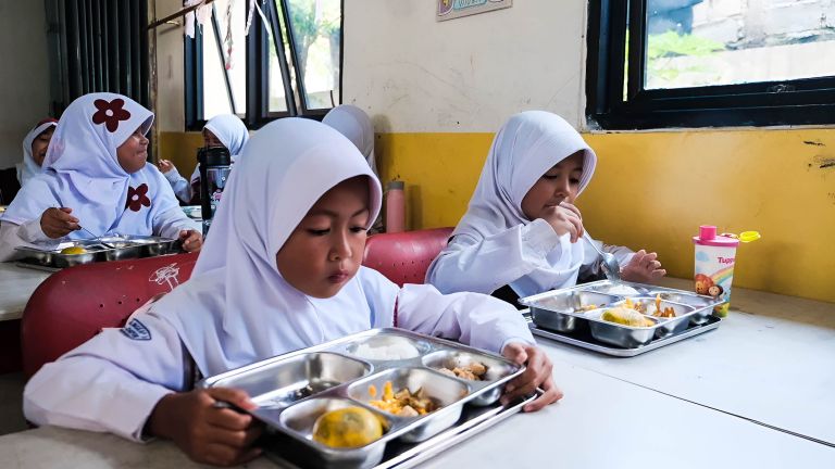 MENIKMATI: Program Makan Bergizi Gratis (MBG) menyasar anak sekolah, seperti siswa Sekolah Dasar, di seluruh Indonesia.
