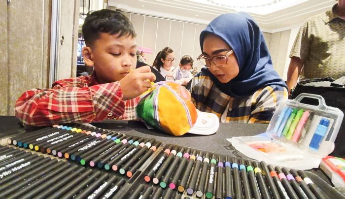 KOMPAK: Icha Oktarika (kanan) mendampingi putranya Atallah Zidan ketika mewarnai topi, dalam Family Colouring Competition yang digelar di Hotel Ciputra Surabaya, Minggu (28/9).