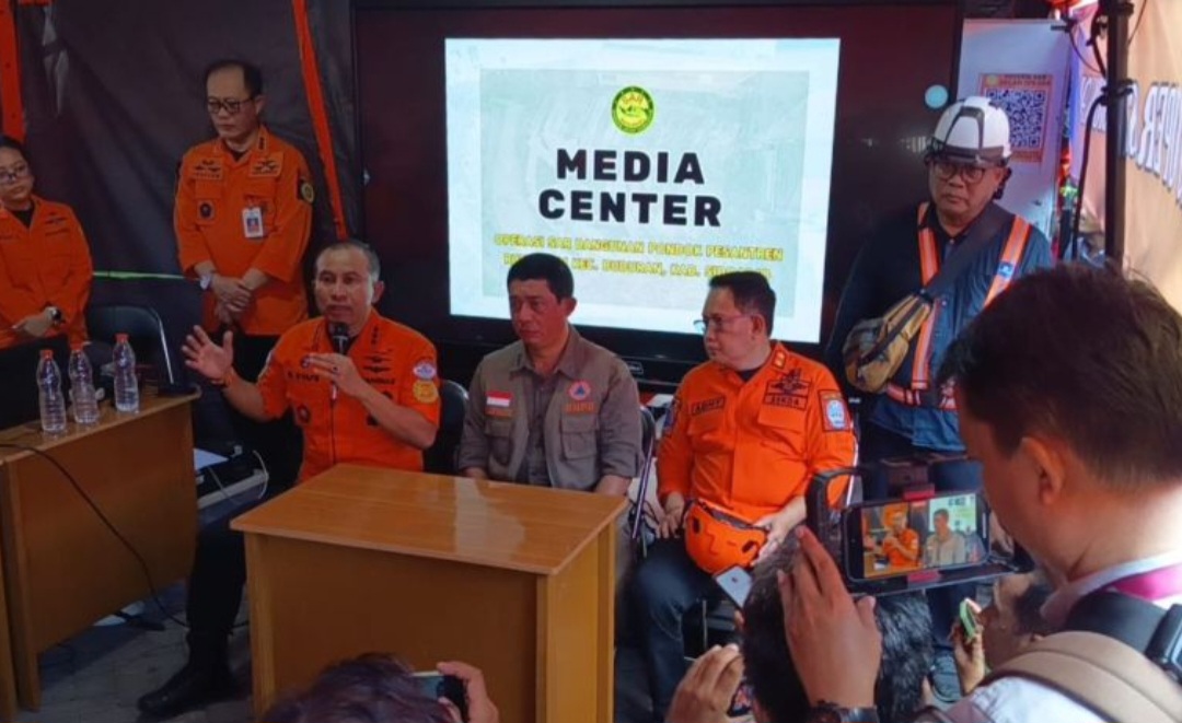 Kepala Badan SAR Nasional (Basarnas) Marsekal Madya TNI Mohammad Syafii (duduk memegang mic) saat memberikan keterangan terkini terkait korban Ponpes Al Khoziny, di Sidoarjo, Rabu (1/10/2025).