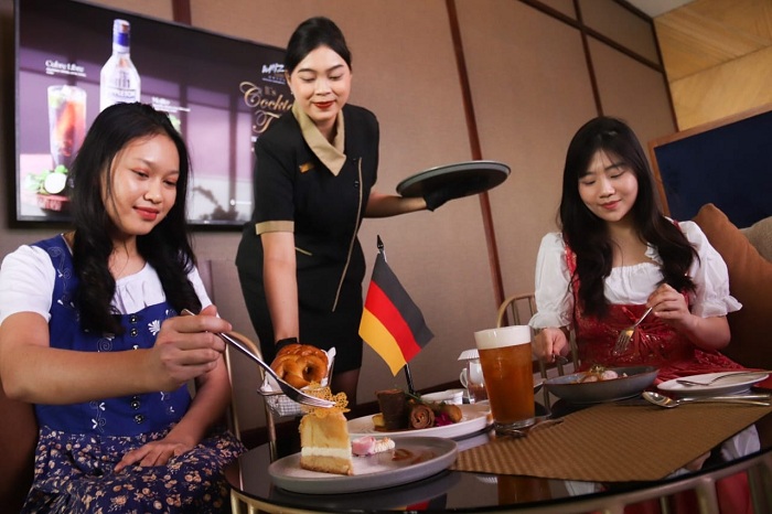 KULINER KHAS JERMAN: Dua orang tamu menikmati sajian menu kuliner khas Jerman, dalam perayaan Oktoberfest di Whiz Luxe Hotel Surabaya, Rabu (1/10).