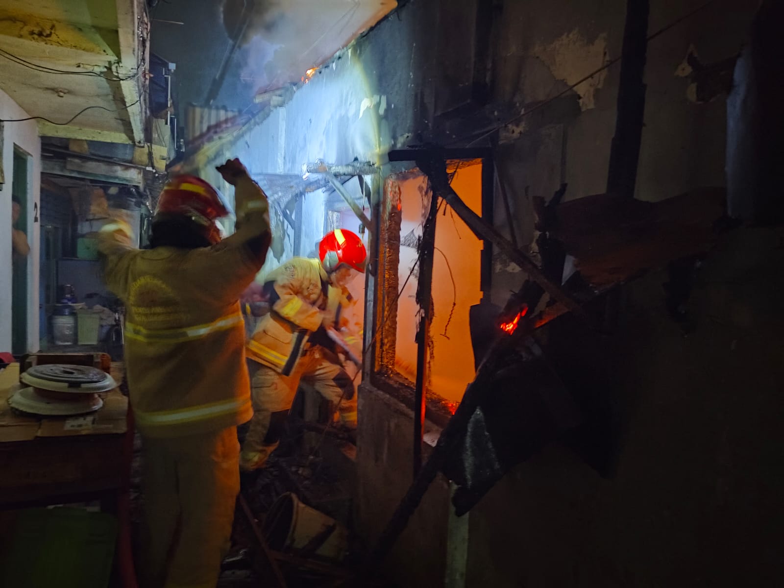 HANGUS : Petugas DPKP Surabaya saat melakukan pemadaman api yang membakar rumah Syaikul M di Jalan Wonokromo Tengah V, Surabaya, Sabtu (4/10).(IST/RADAR SURABAYA)