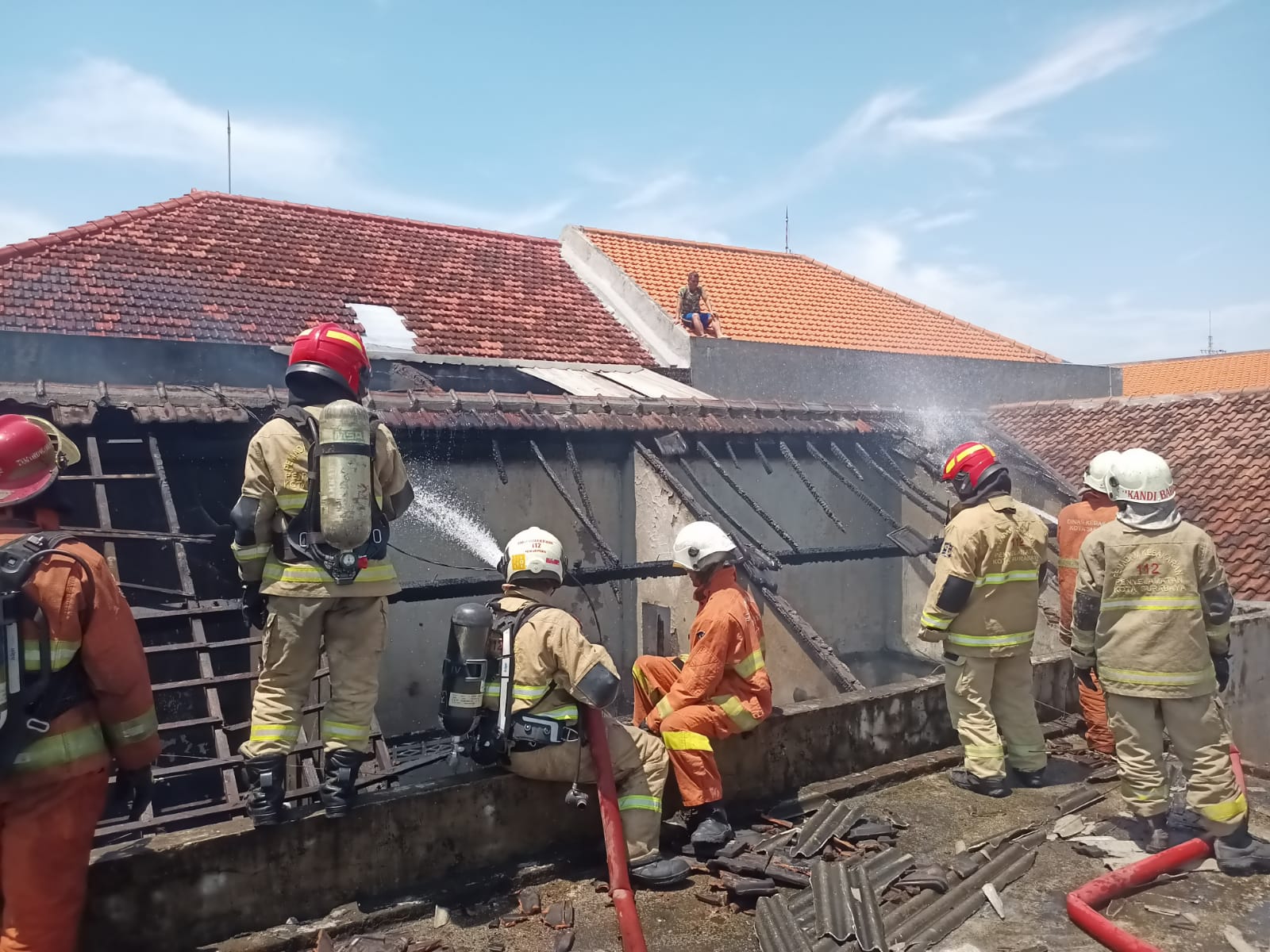 PEMBASAHAN: Petugas DPKP Surabaya saat memadamkan kebakaran rumah di Jalan Bogangin Baru, Surabaya.(IST/RADAR SURABAYA)