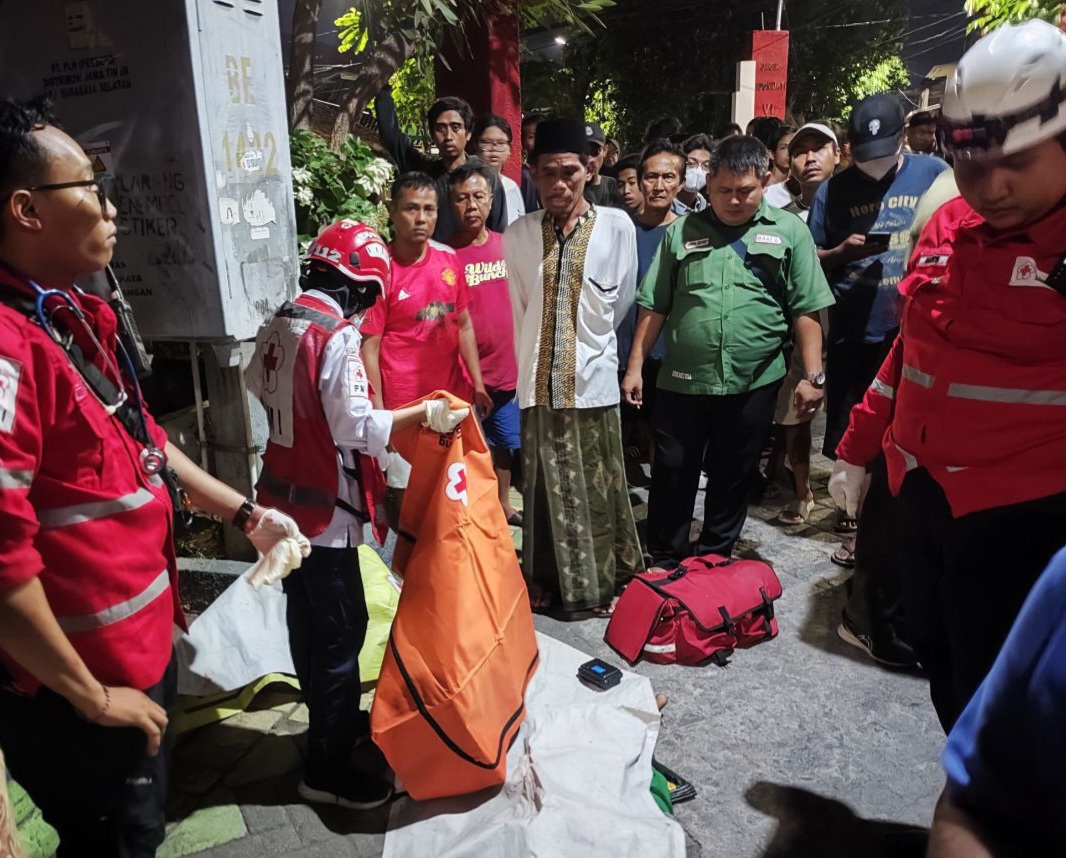 EVAKUASI: Petugas saat mengevakuasi jasad bo ah yang meninggal dunia usai tertabrak mobil listrik di Jalan Jagir Sidomukti VI, Surabaya. (IST/RADAR SURABAYA)