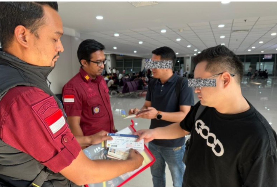 Petugas mendampingi dua warga negara Tiongkok yang dideportasi dari wilayah hukum kantor Imigrasi Kediri, Jawa Timur.