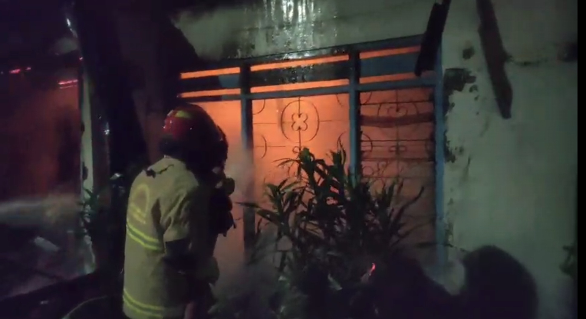 BERJIBAKU: Petugas DPKP Surabaya saat memadamkan api yang membakar rumah aset PT KAI di Jalan Demak Timur, Surabaya. (IST/RADAR SURABAYA)