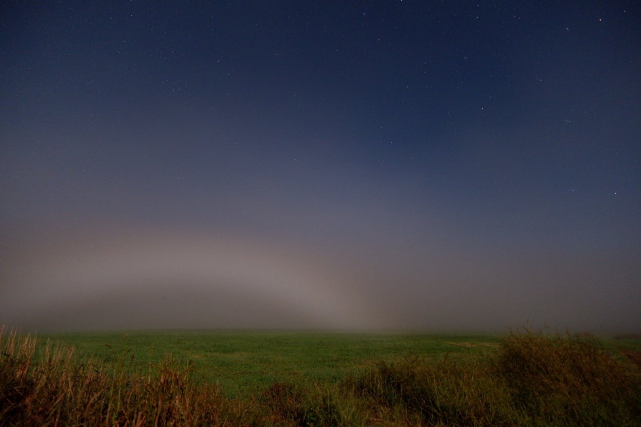 Fenomena langka moonbow atau pelangi malam tampak melengkung indah di langit berbintang.