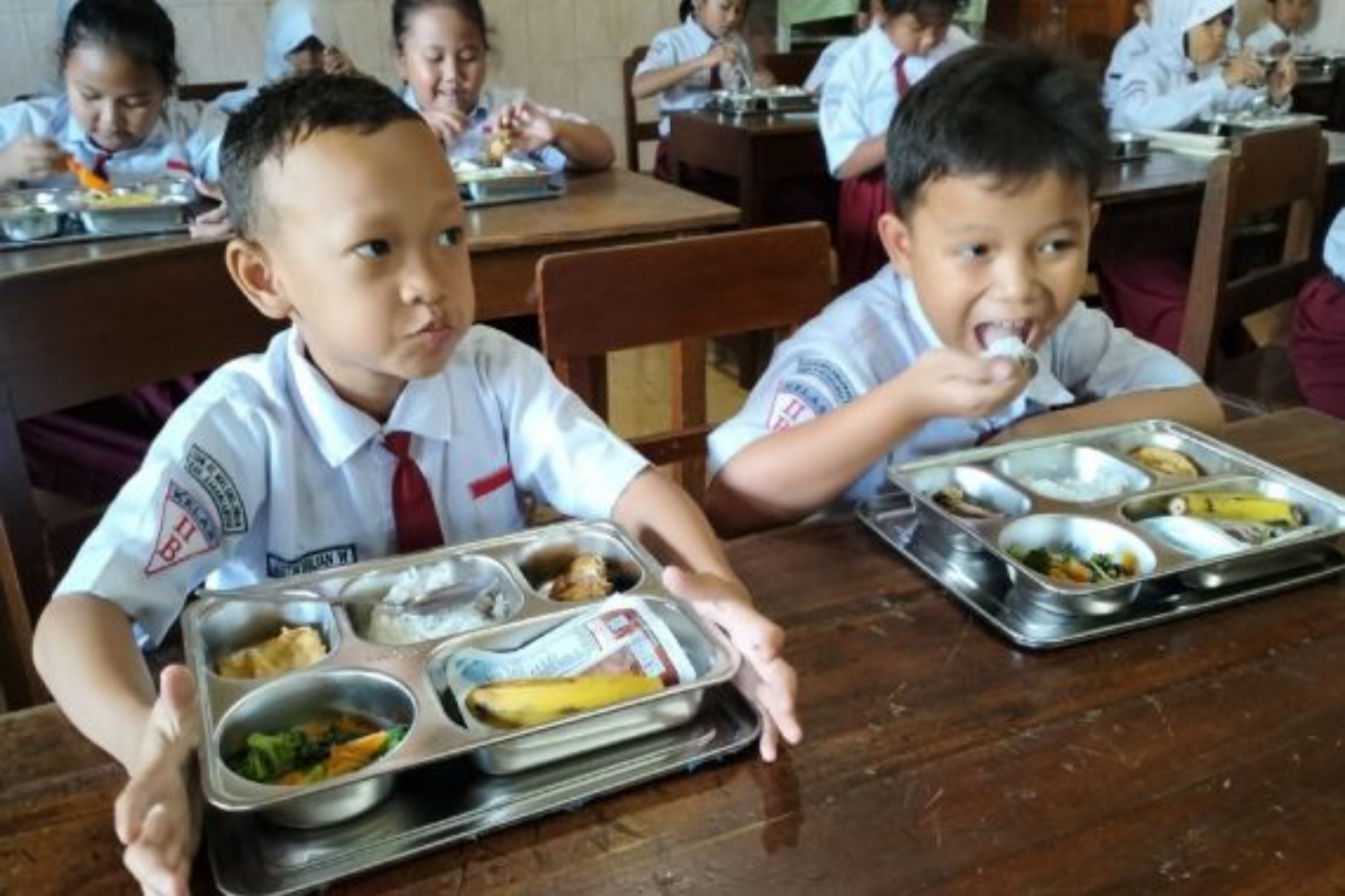 SANTAP: Sejumlah murid sedang menikmati Program Makan Bergizi Gratis (MBG) dari pemerintah.