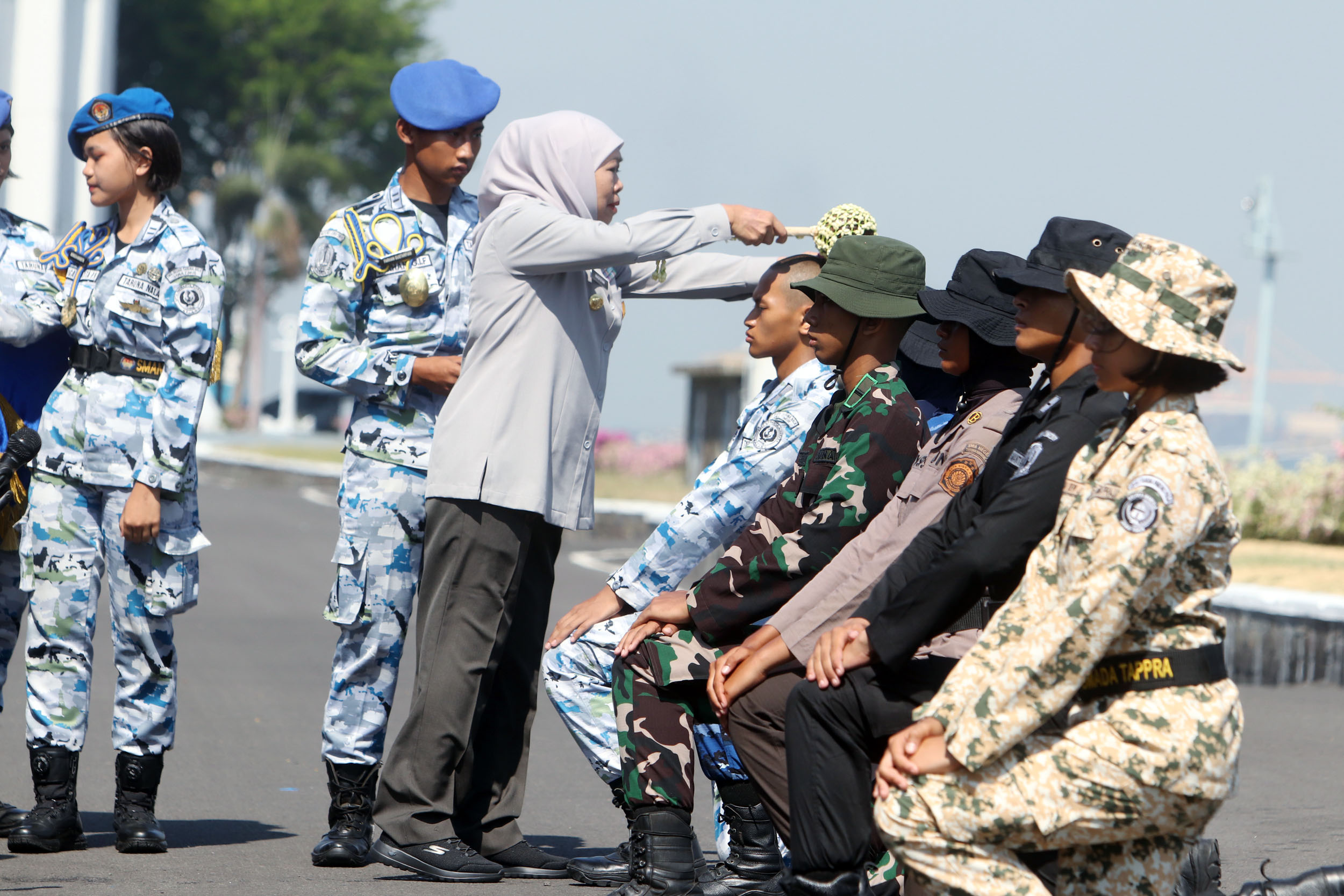 Gubernur Jatim Khofifah Indar Parawansa menyiram air kembang pada kepala para siswa SMAN Taruna saat pembaretan di Dermaga Madura, Koarmada II TNI AL, Surabaya, Kamis (16/10). (ANDY SATRIA/RADAR SURAB