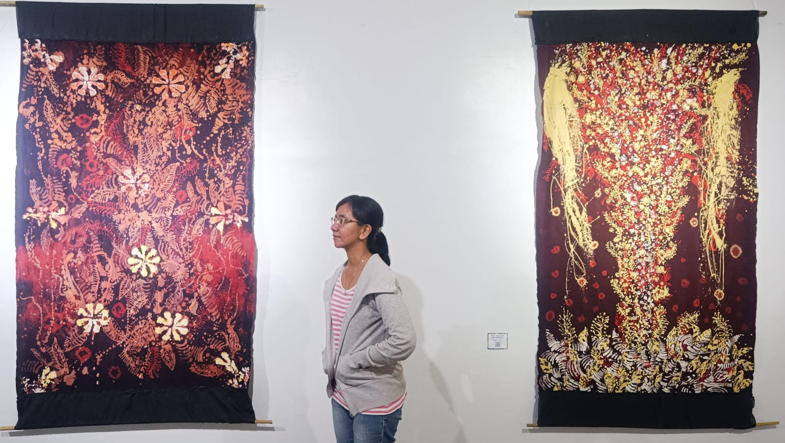 LUKIS MEDIA BATIK: Seorang pengunjung mengamati karya seni lukis yang diaplikasikan dalam media batik, dipamerkan di Galeri Prabangkara, Komplek Taman Budaya Jatim, Jumat (17/10).