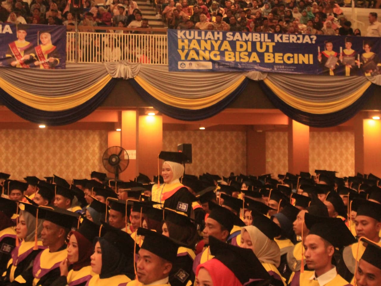 TERBAIK: Wisudawan terbaik UT Surabaya, Tuty Alawiyah dengan IPK 3,91 saat berdiri diantara wisudawan setelah ditawari hadiah dari Gubernur Jatim Khofifah Indar Parawansa.