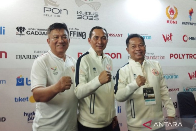 Wakil Ketua Umum III KONI DKI Jakarta Fatchul Anas (tengah) saat jumpa pers di Media Center PON Bela Diri Arena Djarum Kaliputu, Kabupaten Kudus, Jawa Tengah, Minggu (26/10/2025).